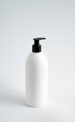 White unbranded bottle with a black dispenser isolated on white background. cosmetic packaging mockup with copy space. Bottle for a shower, gel, soap.