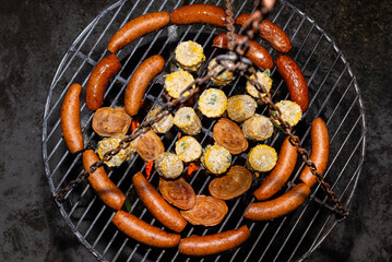 Baking sausages, sheeps cheese and corn on a metal grate fired with birch wood.