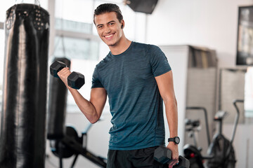 Portrait, dumbbells and man in gym smile with earphones for streaming music while exercising....