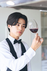 ワイングラスを見つめる男性　ソムリエ　ワインエキスパート