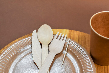 Eco-friendly, disposable, cardboard, paper, non-waste tableware on a brown background close-up. Zero waste. Zero waste concept.