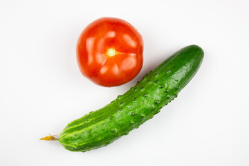 Cucumber and tomato close-up on a white isolated background. Natural ripe vegetables, organic tomato and cucumber.