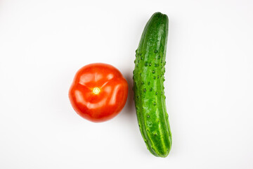 Cucumber and tomato close-up on a white isolated background. Natural ripe vegetables, organic tomato and cucumber.
