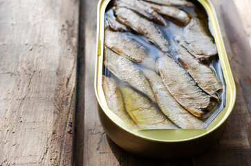 Canned fish on a wooden table. Tinned fish concept. Rustic style. Horizontal orientation. Copy space.