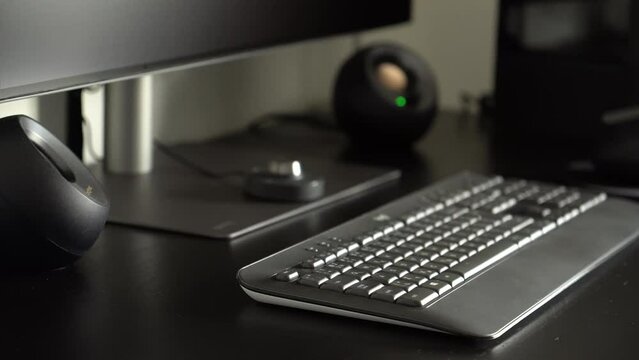 A desktop computer setup on an office table - speakers and a keyboard - closeup
