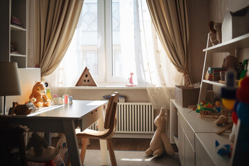 A cozy home office with a wooden desk situated in front of a window with white sheer curtains