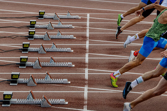 legs runners athletes in Nike sprinting spikes start running from starting blocks Alge-Timing, world championship athletics competition, sports editorial photo