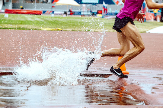 athlete runner running steeplechase in Nike spikes shoes, world championship athletics competition, sports editorial photo