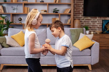 Two children sing song. Concept is childhood, vocal, music, singing. Microphone and headphones.