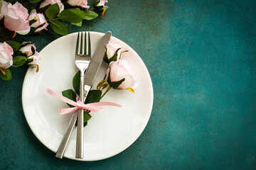 Spring table setting. White plate with cutlery and flowers. Top view with copy space.