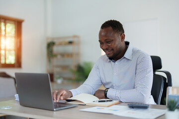 middle aged man American African using computer laptop with planning working on financial document, tax, exchange, accounting and Financial advisor