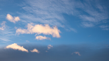 dark blue sky in the evening with lighted cumulus clouds copy space