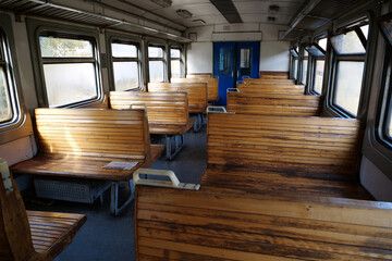 Old empty wagon of train. Wooden seats in an empty coach of train