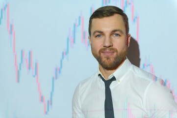 Man is standing near projector and showing graphs and business graphs.