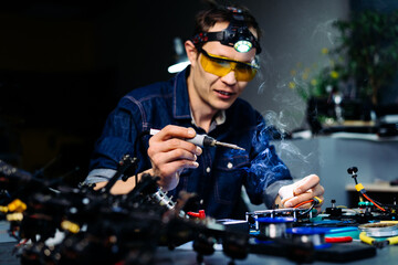 Engineer working on racing fpv drone combat kamikaze bomber in workshop.