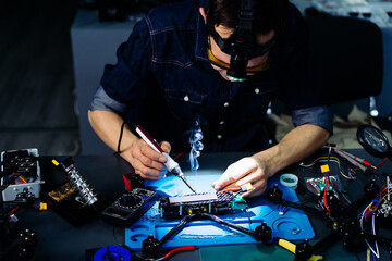 Engineer working on racing fpv drone combat kamikaze bomber in workshop.