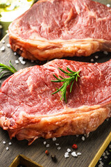 Beef steak with spices. Raw beef meat at cutting board. Close up.
