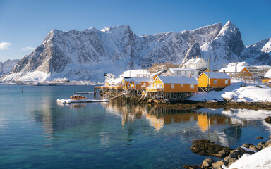 Beautiful view of scenic Lofoten Islands archipelago winter scenery with traditional yellow fisherman Rorbuer cabins in the historic village of Sakrisoy at sunrise, Norway, Scandinavia - obrazy, fototapety, plakaty