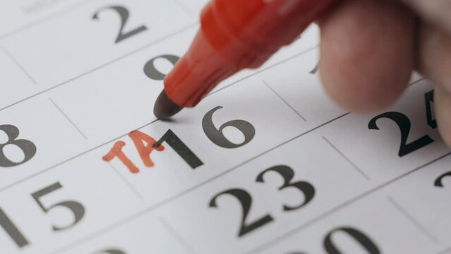 The sixteenth date in the calendar is marked in bold red marker as the day of payment of taxes. Close-up.