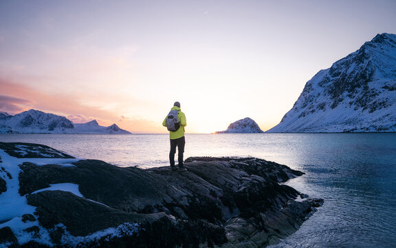 A traveler woman during sunset. Haukland Beach on Lofoten Islands, Norway. Journey and adventure. Winter landscape. Travel - image