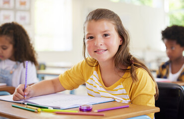 Education, writing and portrait of girl in classroom learning, exam or studying with book....