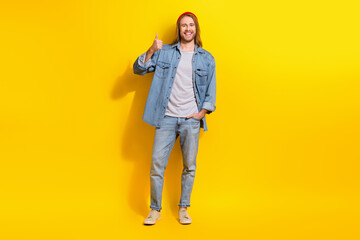 Fototapeta premium Full size photo of cheerful optimistic man wear denim jacket jeans trousers shoes showing thumb up isolated on yellow color background