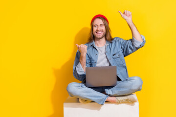 Photo of cool positive guy dressed jeans shirt chatting modern gadget thumbs emtpy space isolated yellow color background