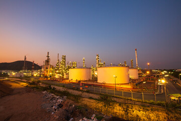 Fototapeta na wymiar Twilight scene of oil refinery plant and storage white tank oil of Petrochemistry industry