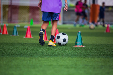 Children playing control soccer ball tactics on grass field with for training