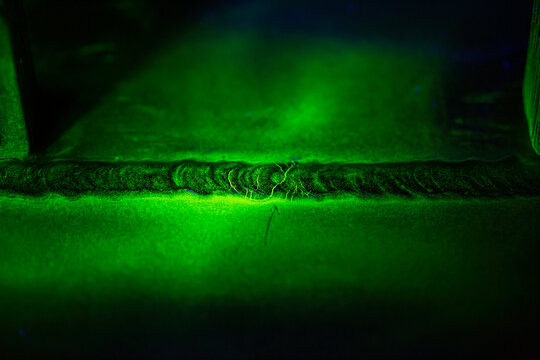 Crack steel butt weld carbon background green contrast magnetic filed