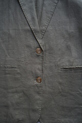 Gray linen jacket hanging on clothes hanger