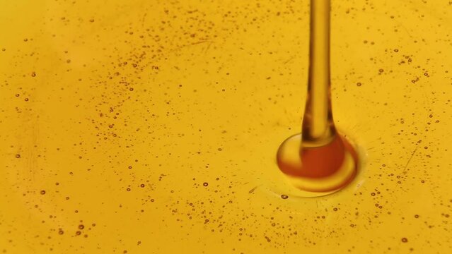 Liquid honey of golden color a trickle of golden honey flows into the honey. 