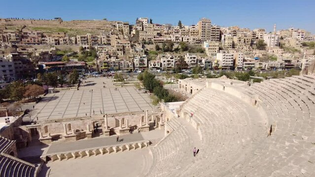 Amman, Jordan: The Roman theater  is a major landmark in Amman, Jordan capital city in the middle east on a sunny day with the citadel on the background. Shot with a panoramic motion.  