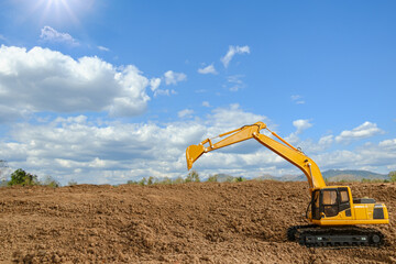 Crawler excavators are digging soil at construction site . on clouds sky and sun backgrounds.