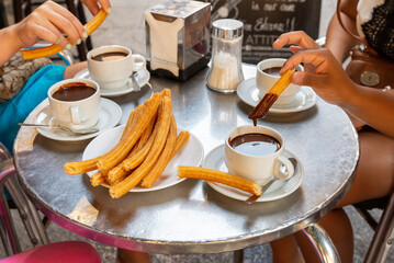 People eating churros and hot chocolate drinks, Madrid, Spain