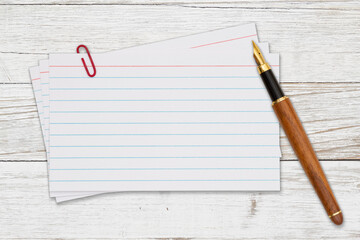 Retro white paper index cards with pen on weathered wood