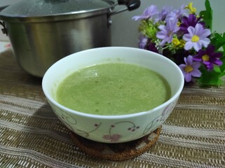 Green tapioca pearl porridge with coconut milk, served in a white bowl. Ready to eat.