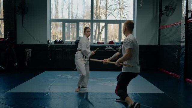 Two fighters practicing with a wooden sword in Aikido Sport and martial arts concept