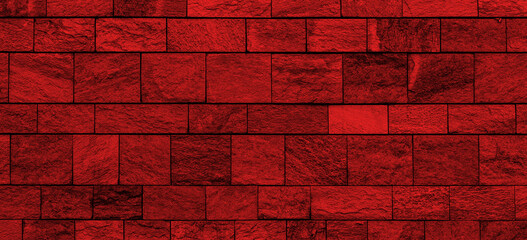 Wide old stone wall texture with red lighting. Panoramic stone block wall background with red light for banner design