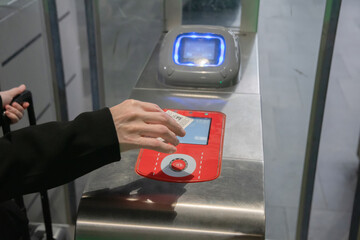 young woman scanning an e-ticket at the terminal at the subway gate