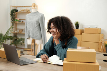 American African entrepreneur smile and checking online order. Successful SME entrepreneur concept