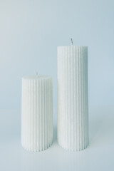 two white candles on a plain white background