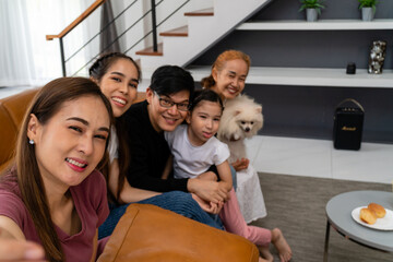 A smiling family takes selfies in the living room of the house.