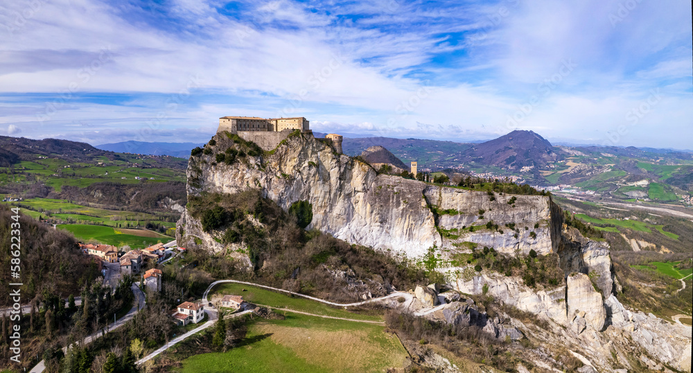 Wall mural Unique beautiful places of Italy. Emilia Romagna region. Aerial drone view of impressive San Leo medieval castle located in the top of sandstone rock and village