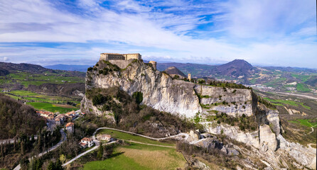 Unique beautiful places of Italy. Emilia Romagna region. Aerial drone view of impressive San Leo medieval castle located in the top of sandstone rock and village