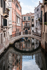 Fototapeta na wymiar Alte Häuser, Steinbrücke und Kanal in Venedig, Hochformat