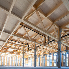 modern industrial hall with timber trusses and prefabricated concrete columns with many glass facade elements