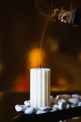 white extinguished candle on a black background