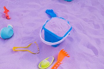 Plastic children's toys for playing on the purple sand.