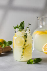Homemade lemonade with fresh lemon slices and mint leaves in a glass. A summer refreshing drink.